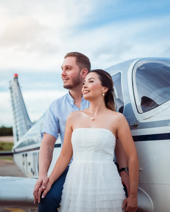 Ensaio pré-wedding de casal ao lado de um avião