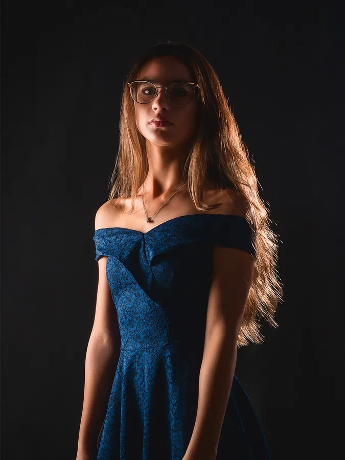 Retrato feminino com vestido azul e iluminação de estúdio