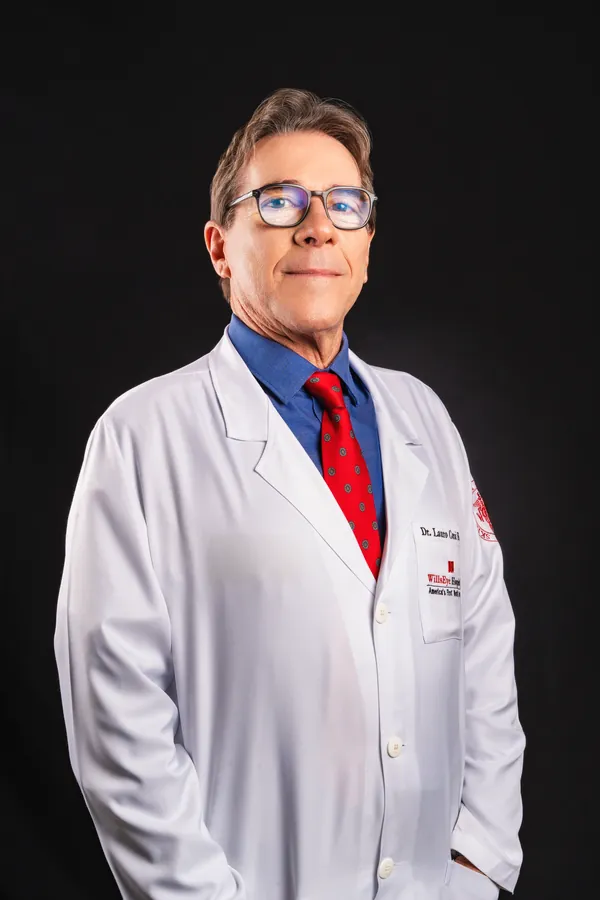 Retrato corporativo de médico de jaleco em fundo escuro