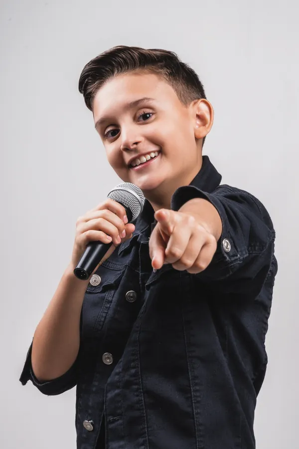 Retrato de jovem cantor com microfone em fundo claro