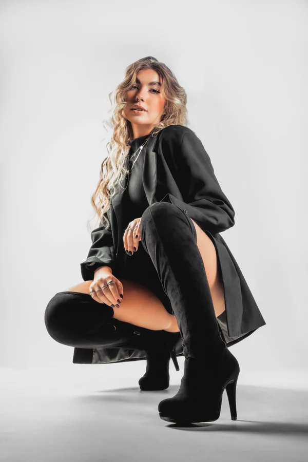 Retrato de moda feminino com botas em fundo branco